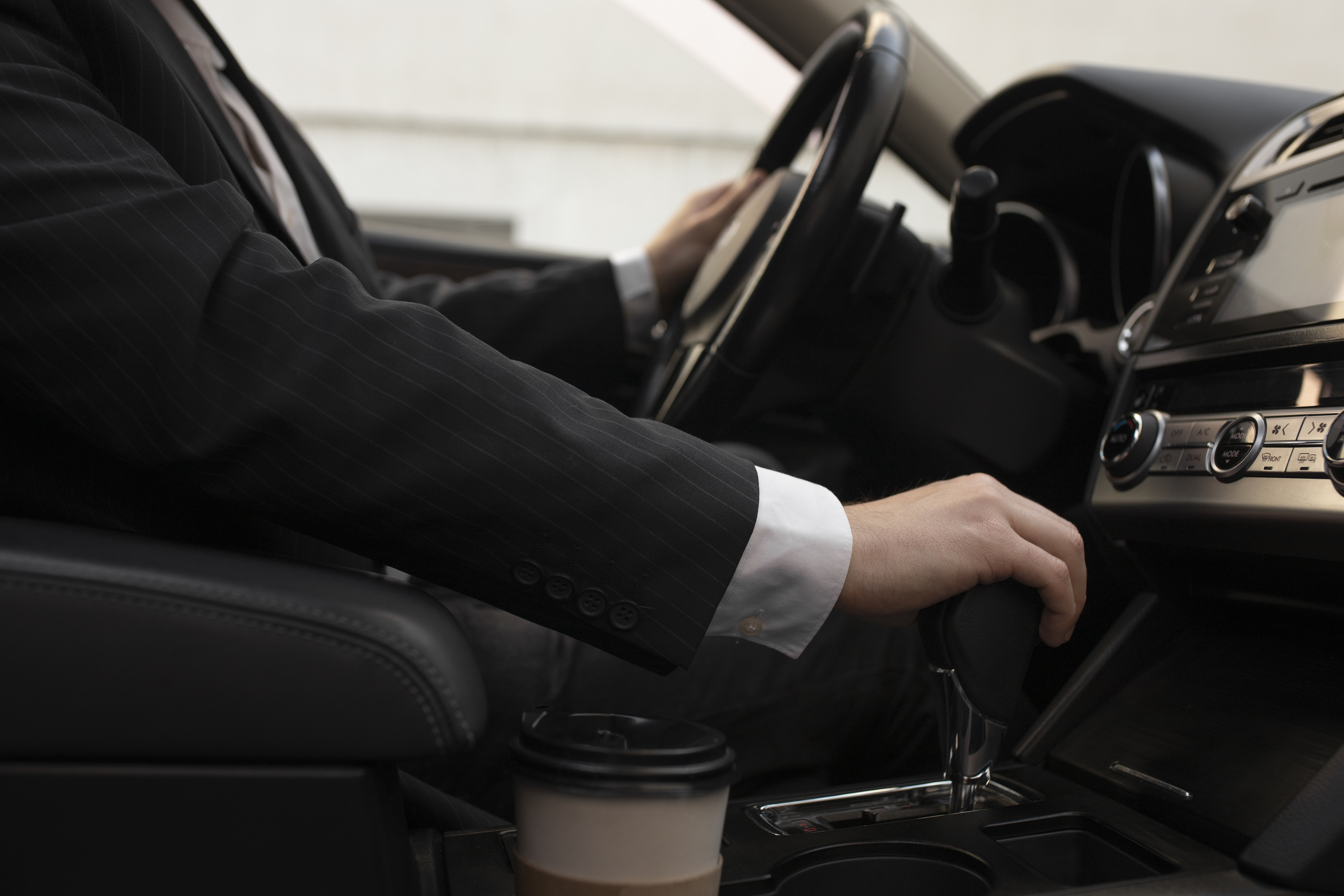 homme utilisant les options de sa voiture en conduisant